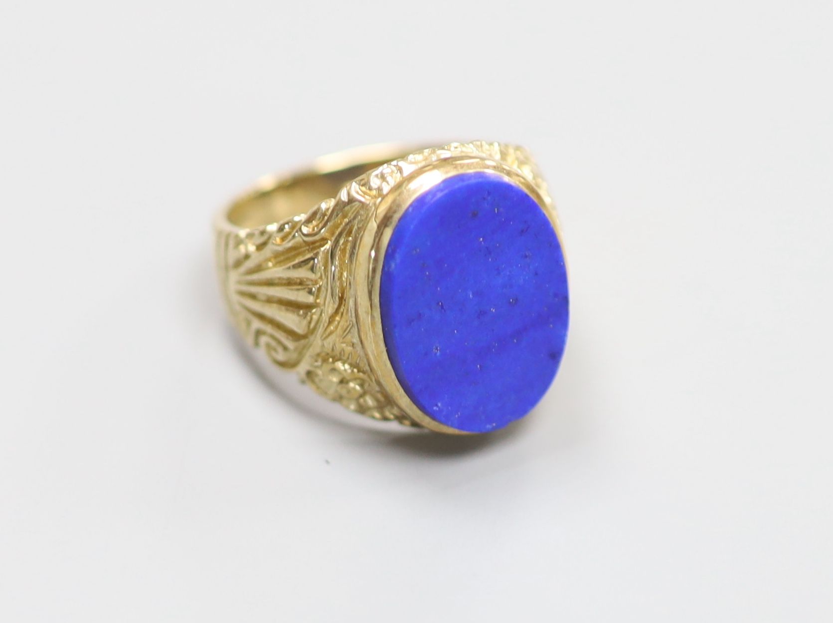 A modern 9ct gold and lapis lazuli set oval signet ring, with carved shoulders, size O